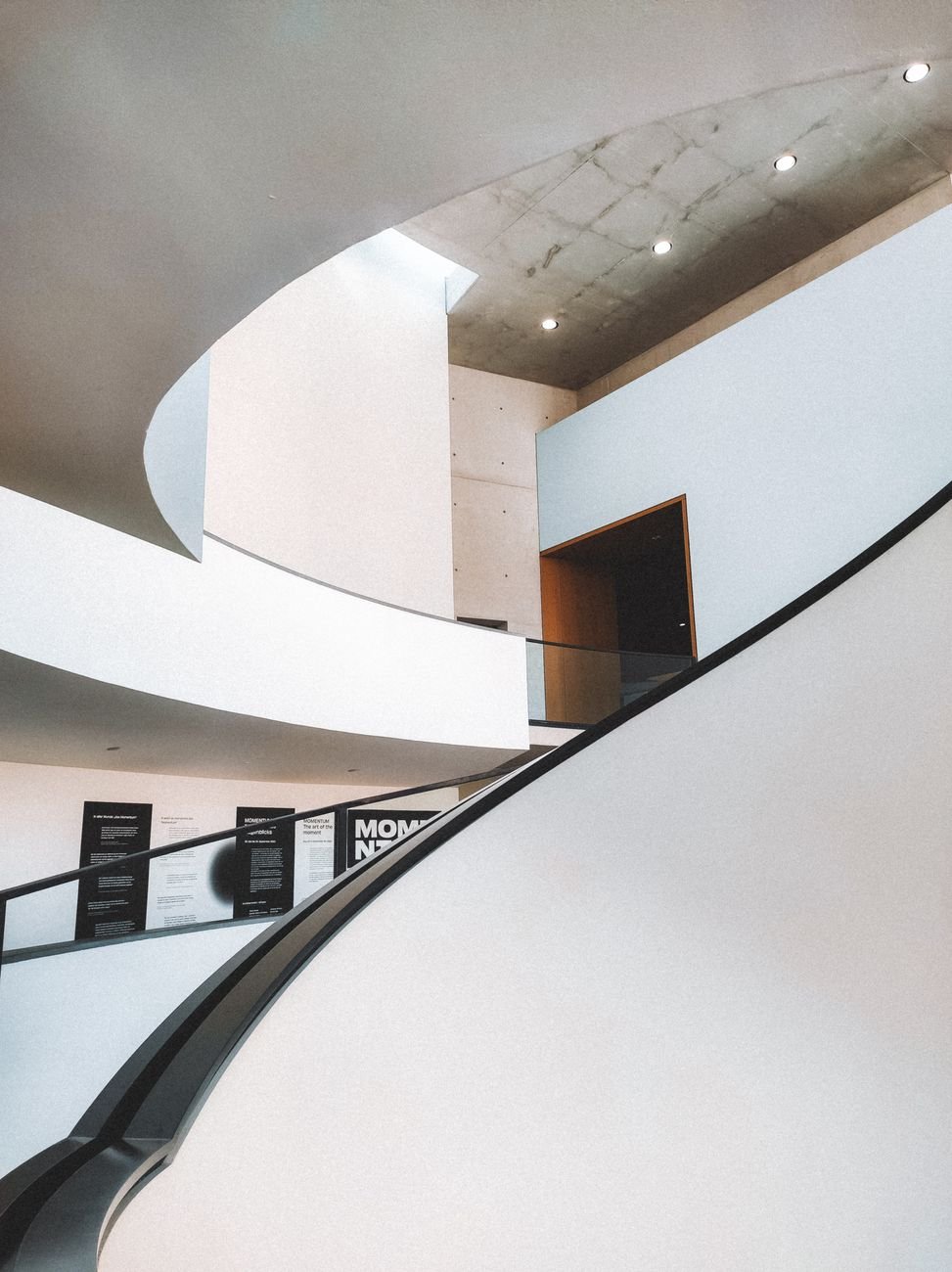Stylish modern interior featuring a sleek curved staircase and minimalist design.